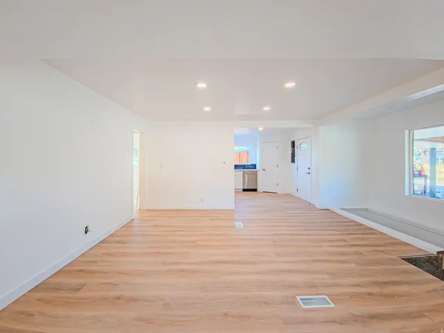 Wood-finish flooring throughout, recessed lighting, and a kitchen with stainless steel appliances