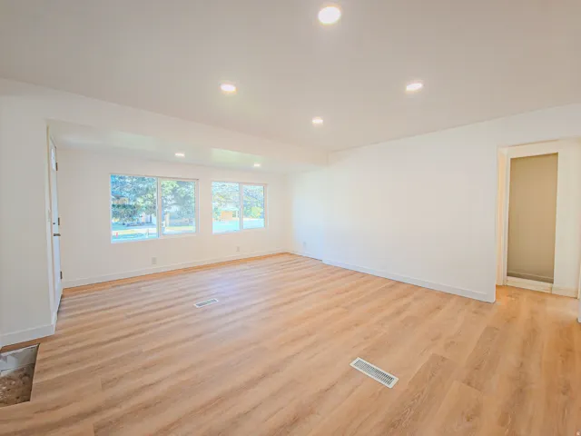 Recessed lighting, wood-finish flooring, white walls, and multiple windows