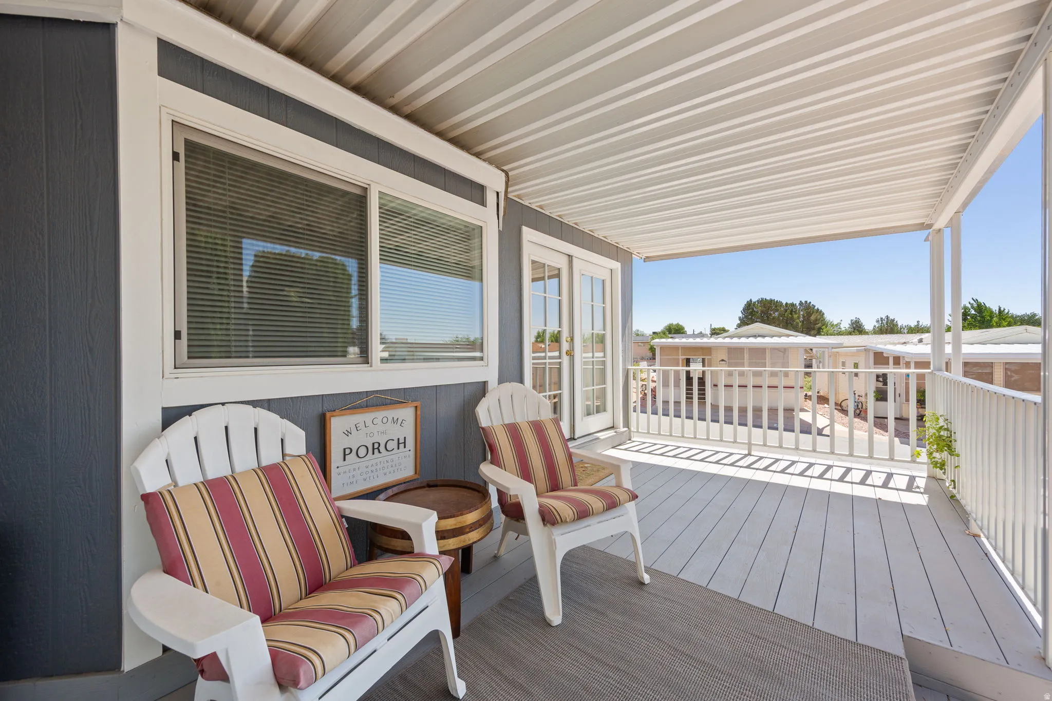 Covered exterior porch featuring a durable composite deck and white railing