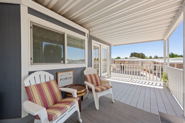 Covered exterior porch featuring a durable composite deck and white railing
