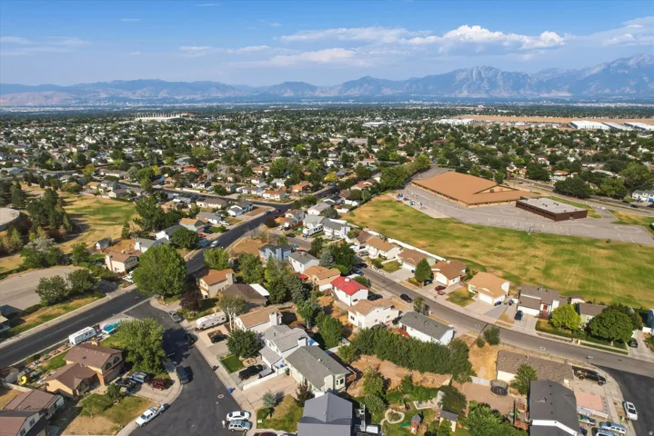Expansive aerial perspective showcasing a residential neighborhood with distant mountain ranges