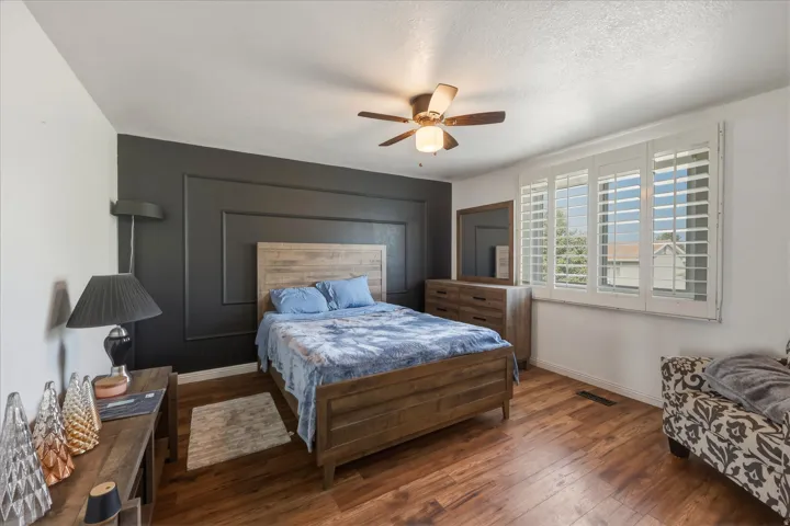 Spacious room featuring wood-finish flooring and a ceiling fan with integrated lighting