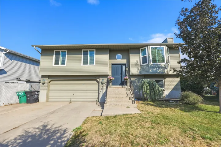 Split-level residence featuring a two-car garage, bay window, and concrete driveway