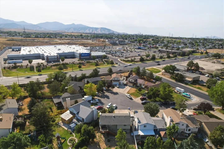 Aerial perspective highlighting residential properties, commercial establishments, and a mountainous backdrop