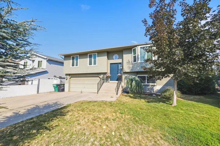 Split-level residence featuring a two-car garage and a paved driveway