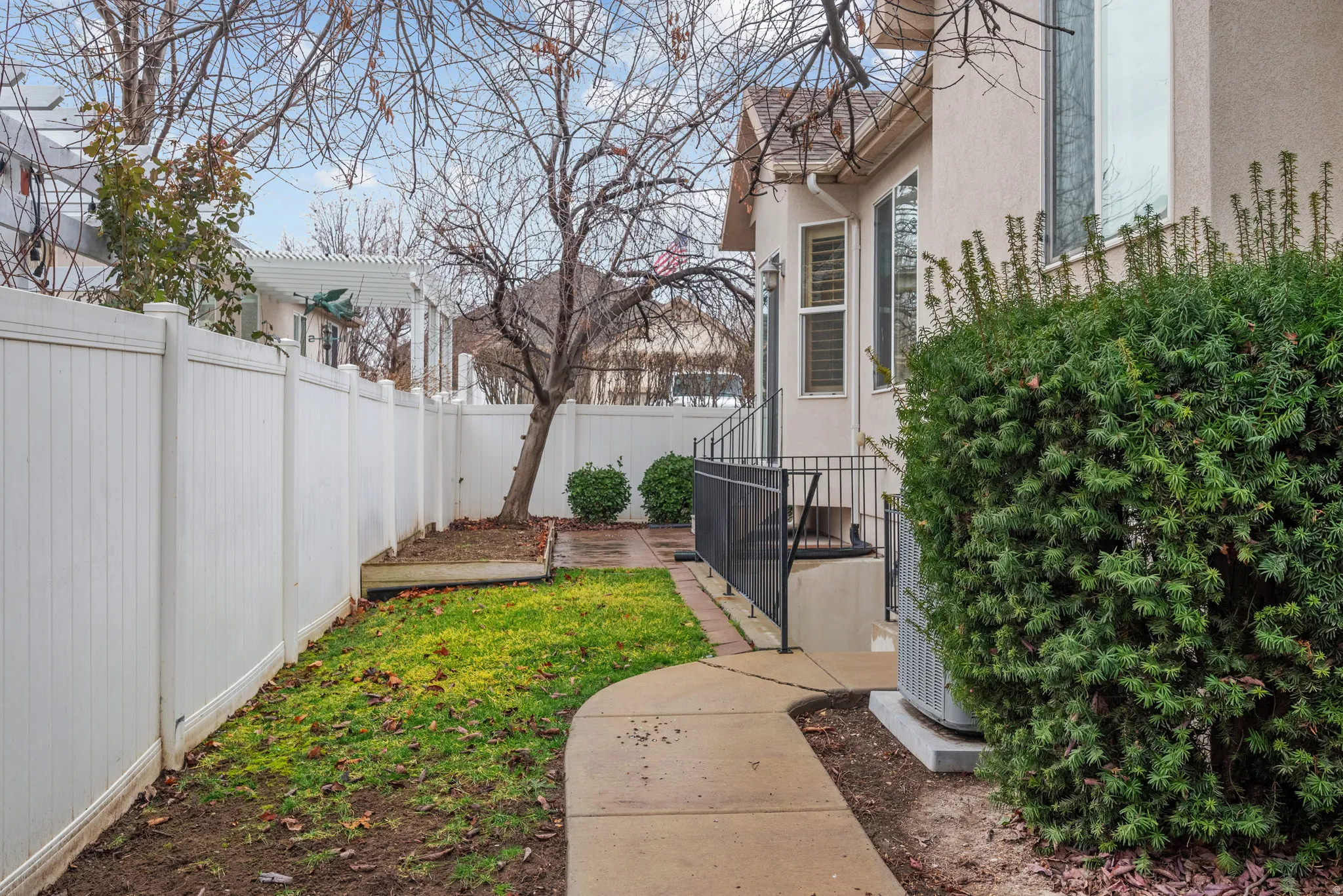 Concrete pathway leading to a stucco exterior with multiple windows