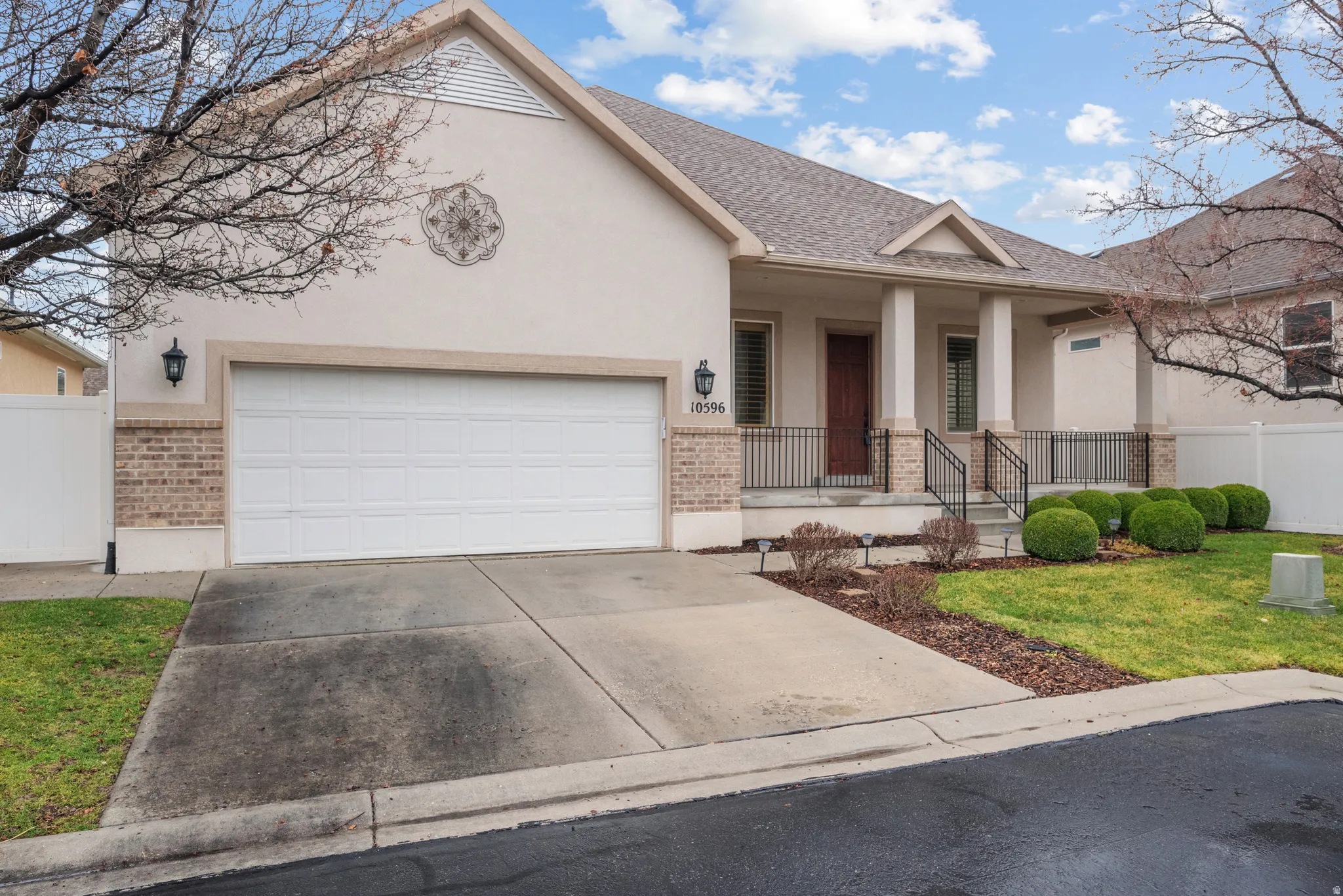 Stucco and brick exterior with a prominent two-car garage