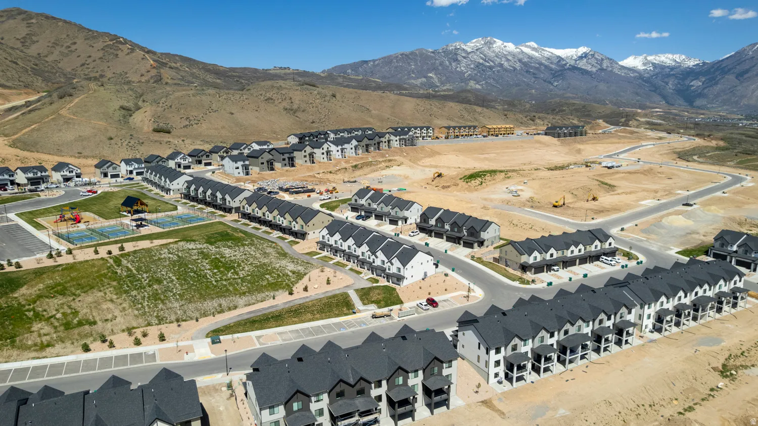 Aerial perspective showcasing a developing residential community with contemporary townhomes and single-family residences