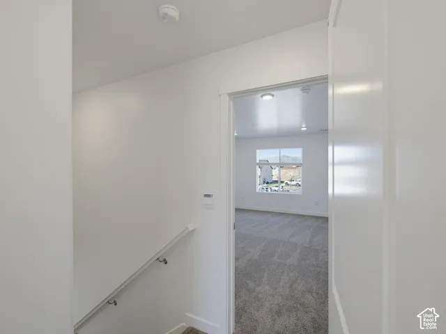 Carpeted room with recessed lighting and a single window