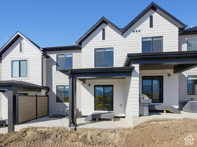 Exterior featuring horizontal siding, multiple sliding glass doors, a covered patio, and a privacy fence