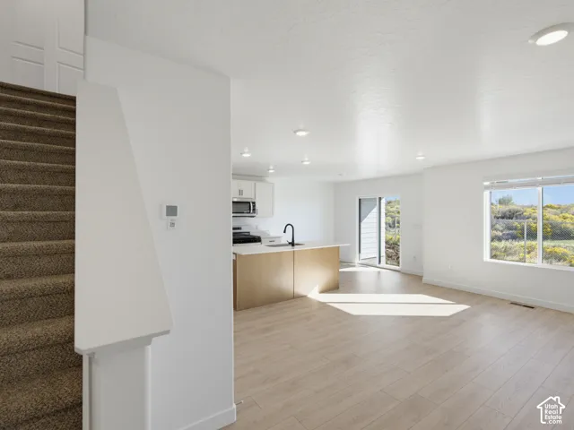 Open-concept living space featuring wood-finish flooring and recessed lighting