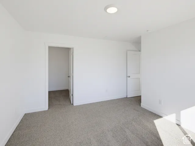 Neutral-toned wall-to-wall carpeting throughout