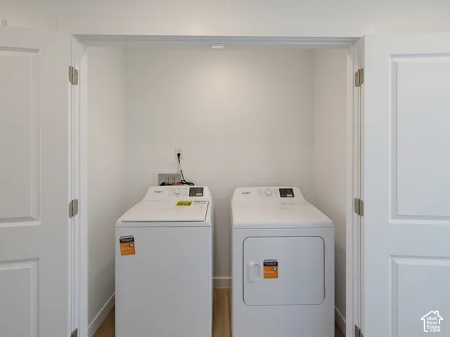 Dedicated laundry closet with wood-finish flooring and white paneled doors