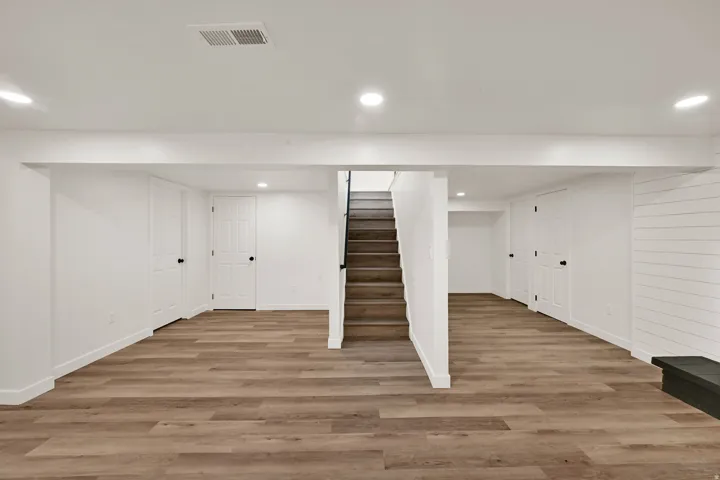 Spacious finished lower level featuring wood-finish flooring, recessed lighting, and crisp white walls