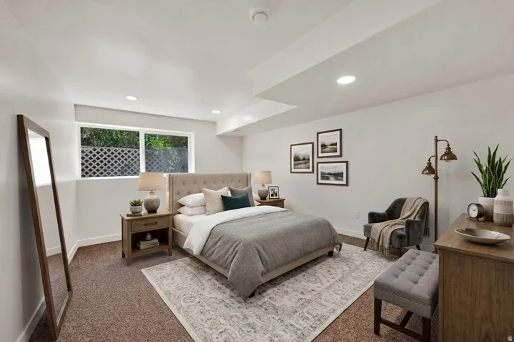 Carpet flooring in a neutral tone and a window featuring a decorative privacy screen