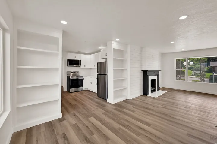 Open-concept living space featuring wood-finish flooring, recessed lighting, and a white shiplap accent wall