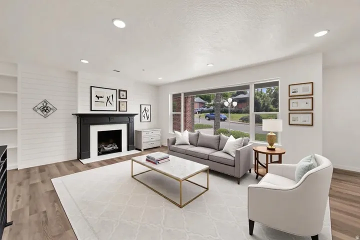 Living area featuring a black mantel fireplace with white surround, recessed lighting, and built-in shelving