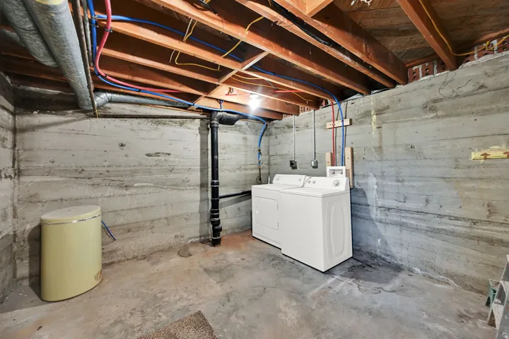 Exposed wood ceiling joists and concrete foundation walls define this utility space