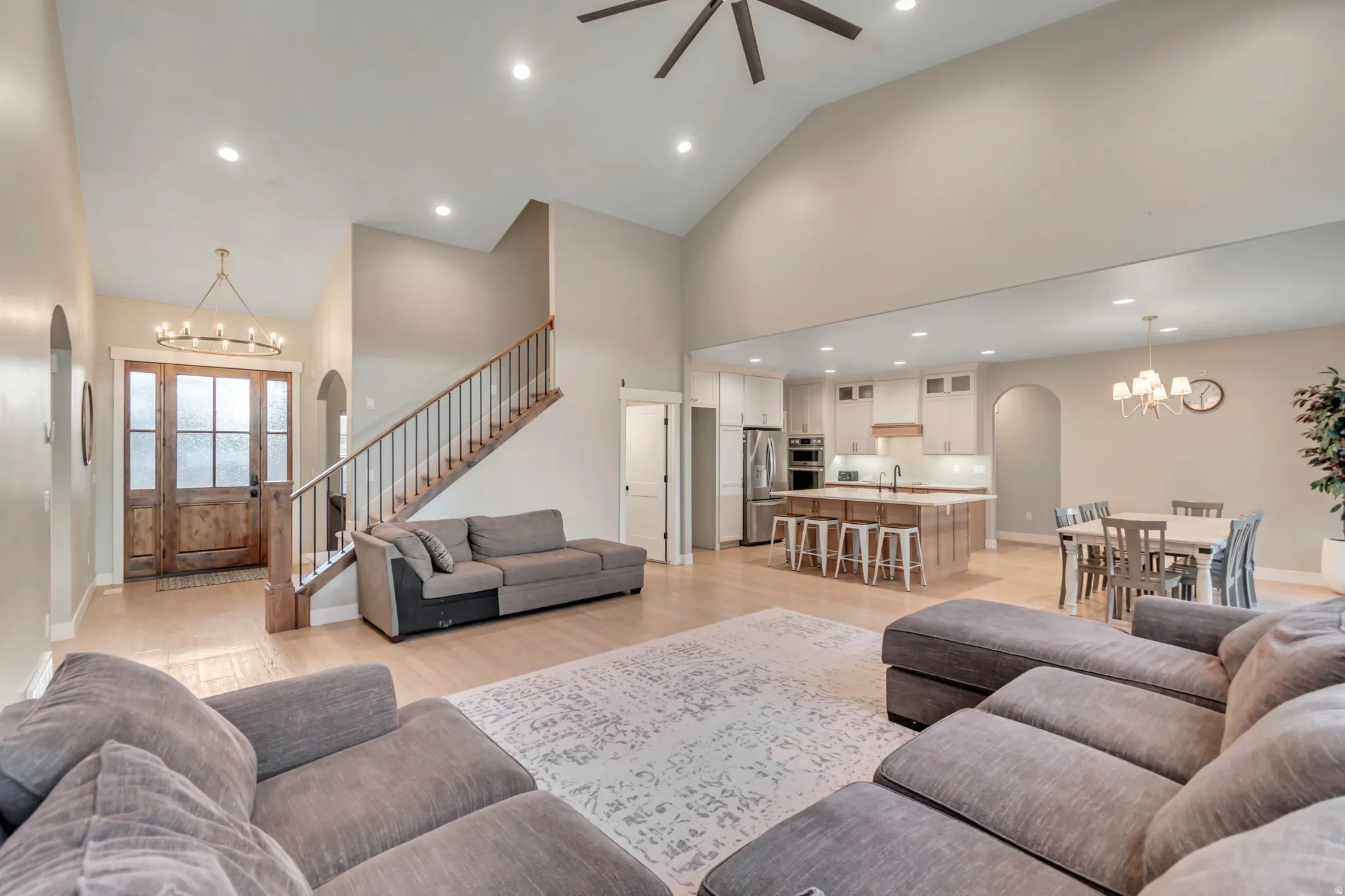 Open-concept living space featuring vaulted ceilings and light wood-finish flooring