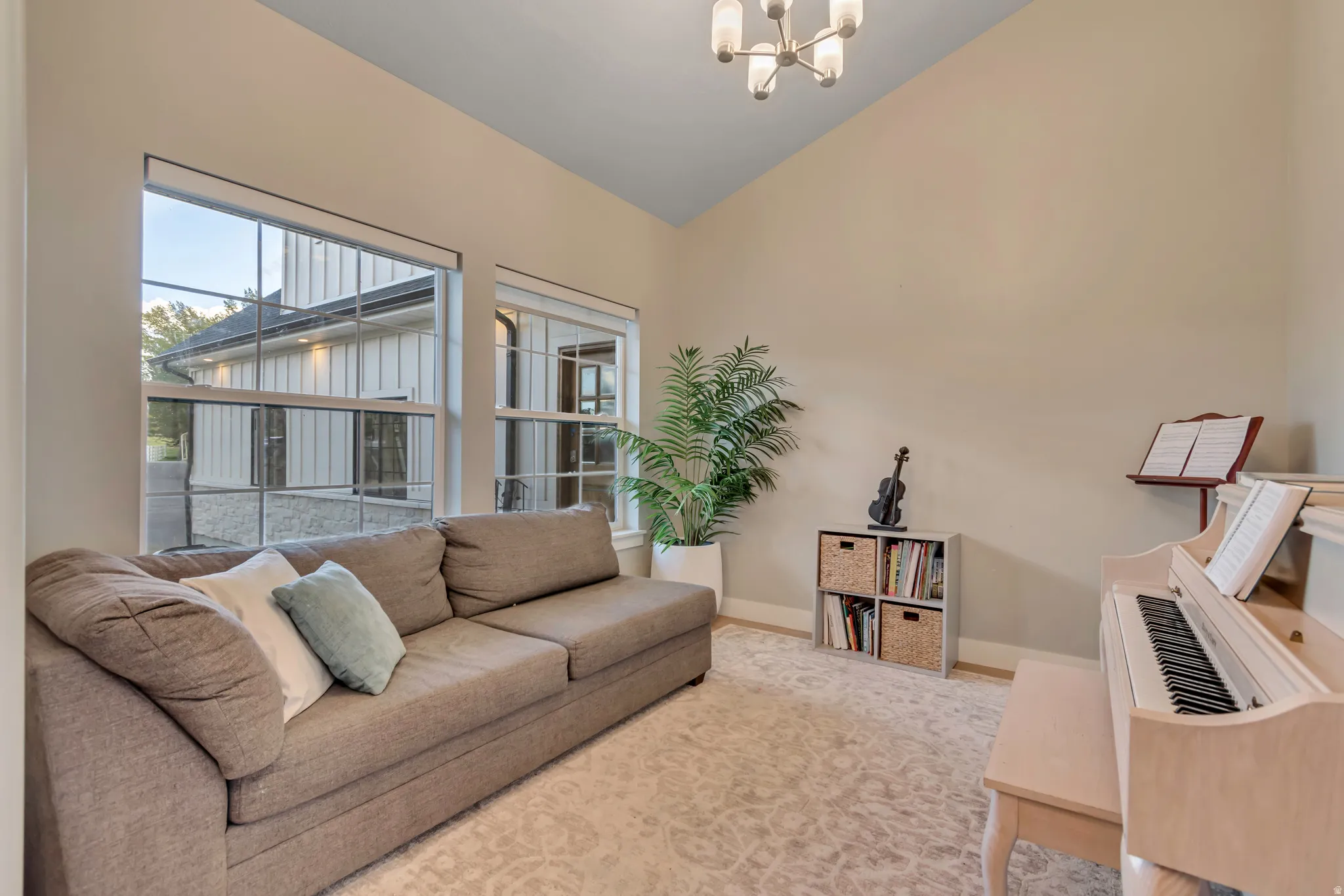 Vaulted ceiling with a contemporary chandelier, neutral wall tones, and recessed lighting