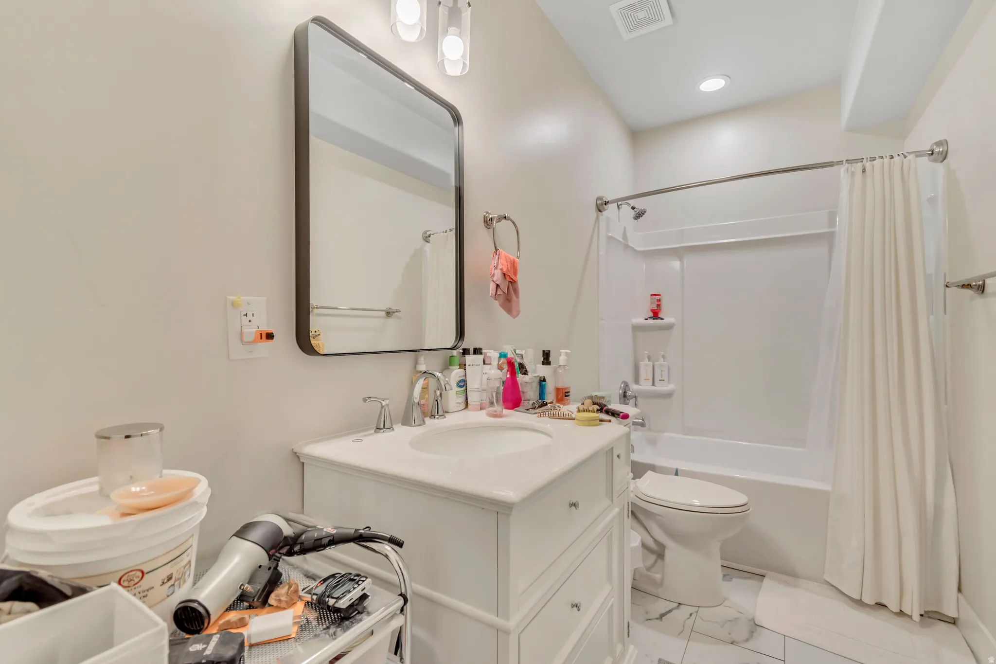 Bathroom featuring a white vanity with an undermount sink, a framed mirror, recessed lighting, a bathtub with a shower kit, and tile flooring