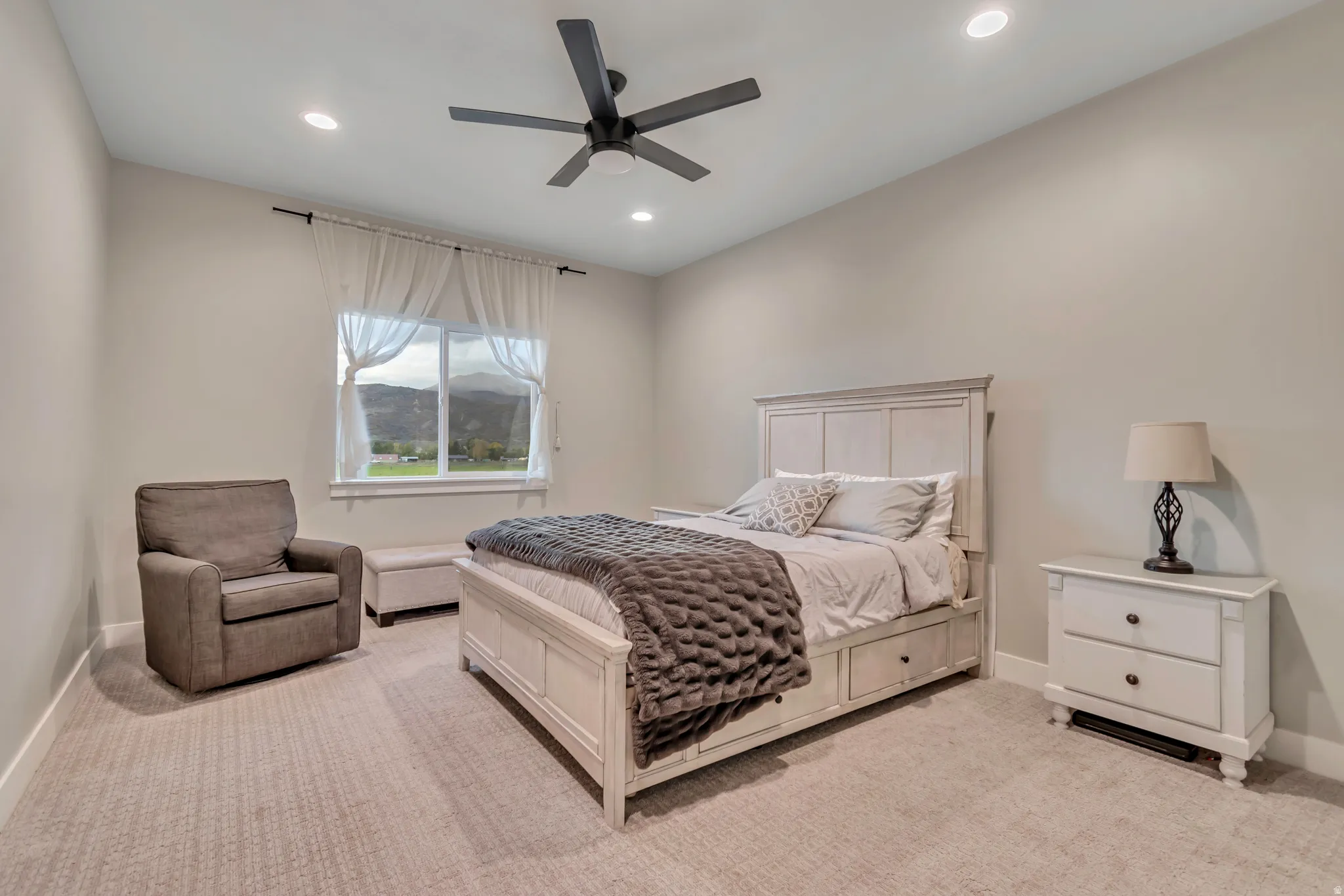 Carpeted room with recessed lighting, a ceiling fan, and a window with mountain scenery