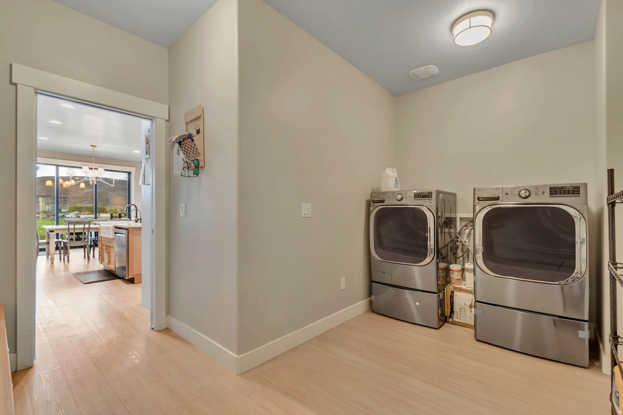 Utility room featuring light wood-finish flooring, neutral wall paint, and a flush-mount ceiling light
