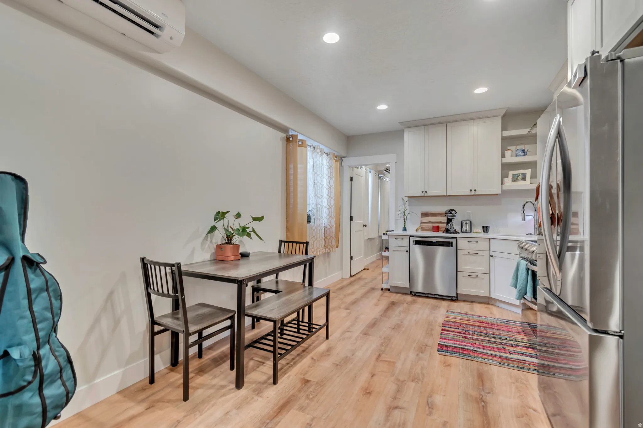 Kitchen featuring wood-finish flooring, white cabinetry, stainless steel appliances, recessed lighting, and a white countertop