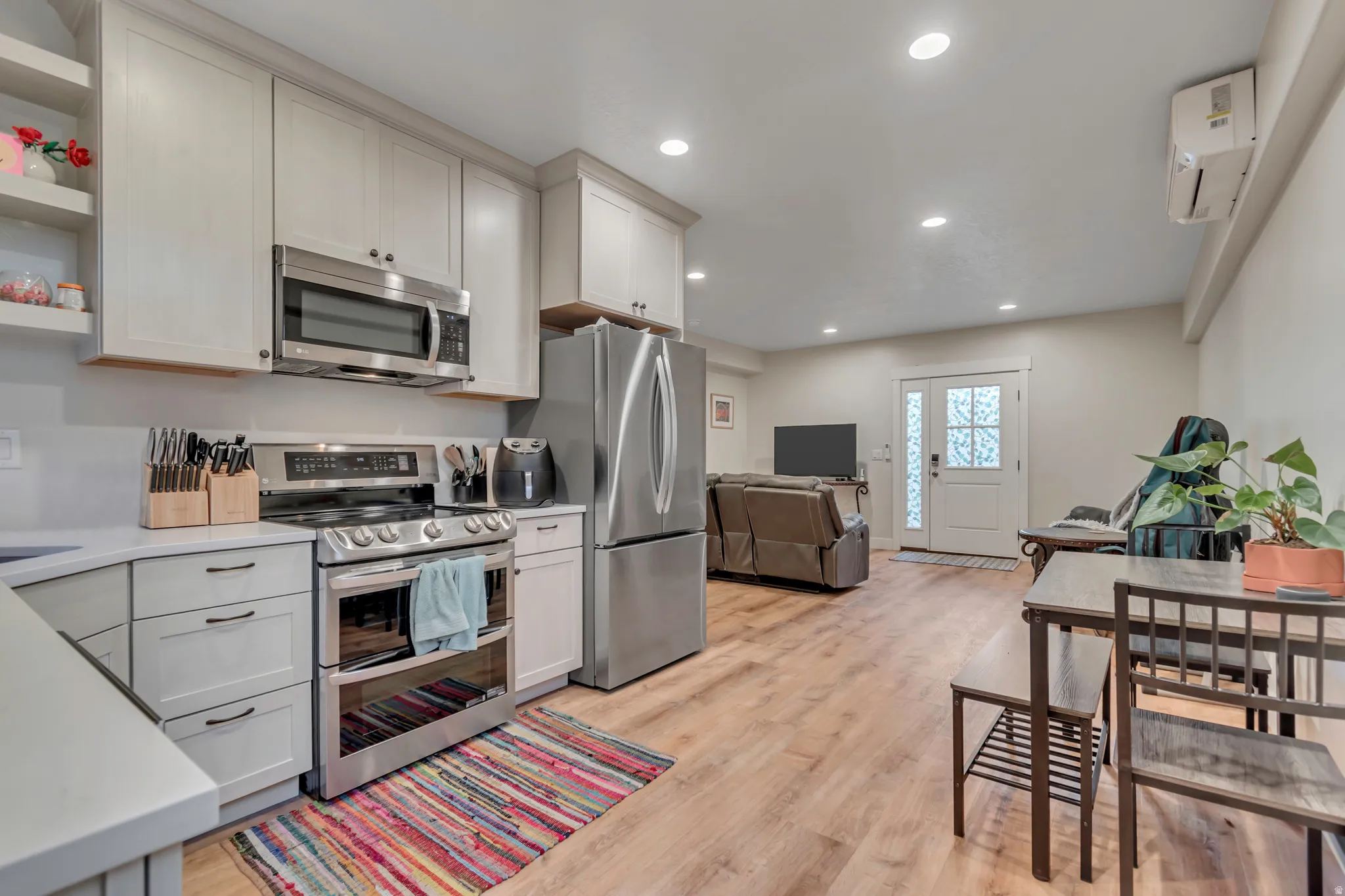 Kitchen featuring stainless steel appliances, light gray cabinetry, and light countertops