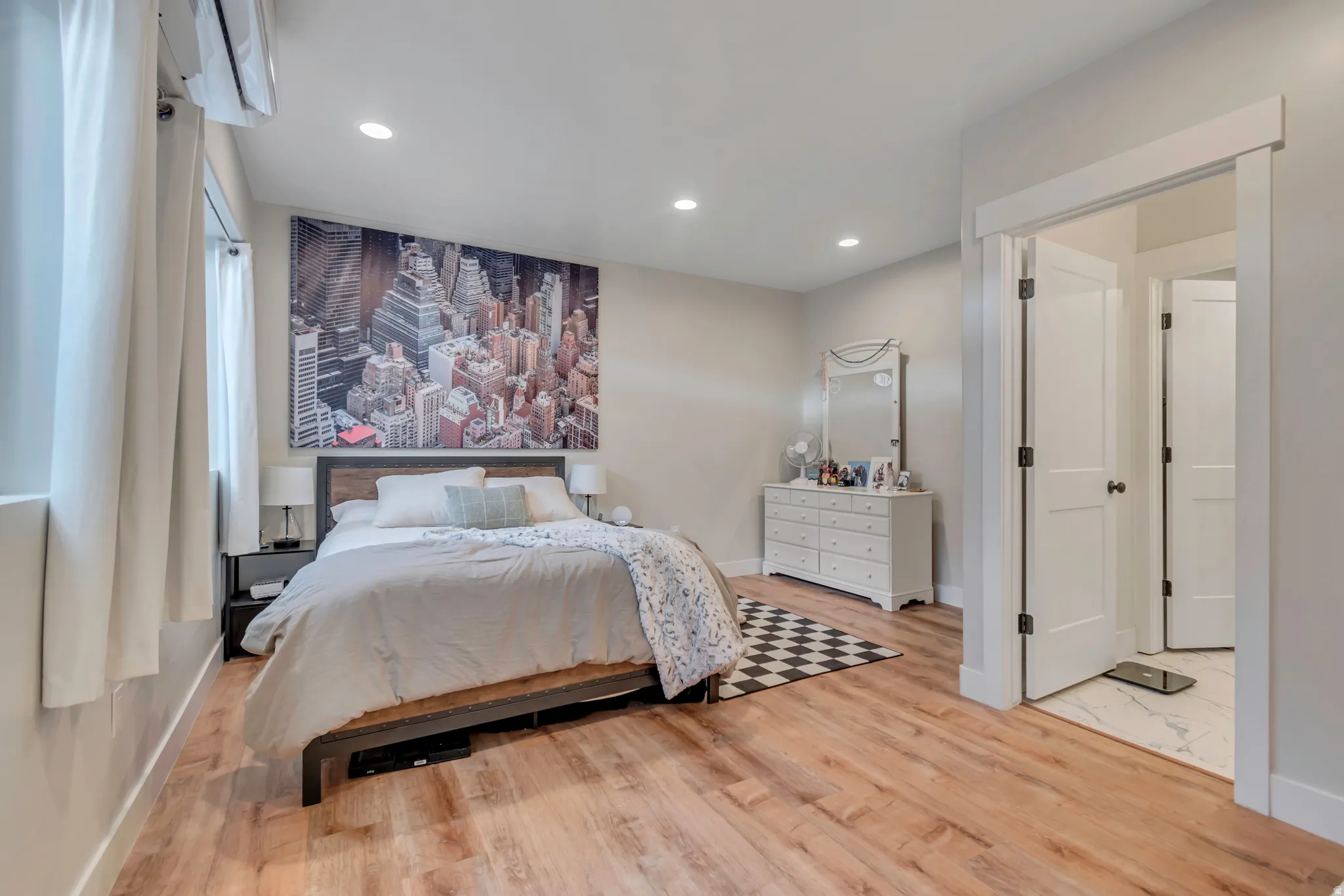 Spacious room featuring wood-finish flooring, recessed lighting, and bright white trim
