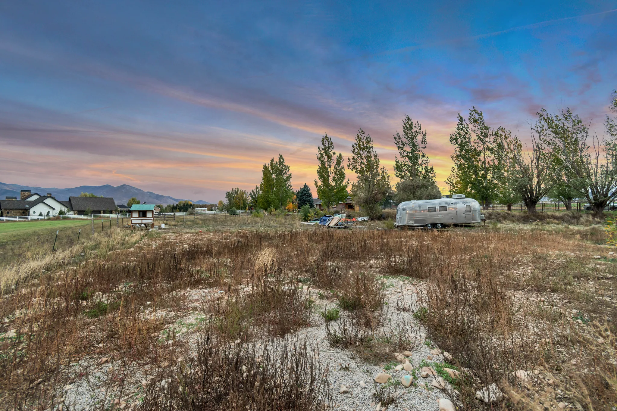 Expansive land parcel with distant mountain backdrop, featuring a flat, open topography