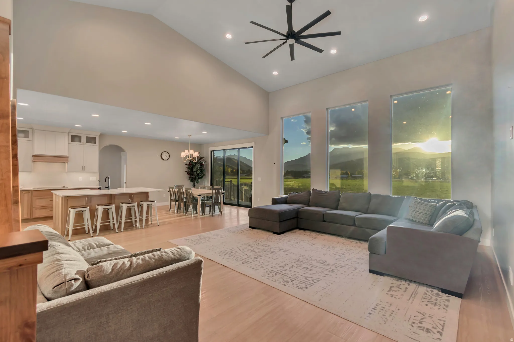 Expansive open-concept living area featuring a vaulted ceiling and light wood-finish flooring