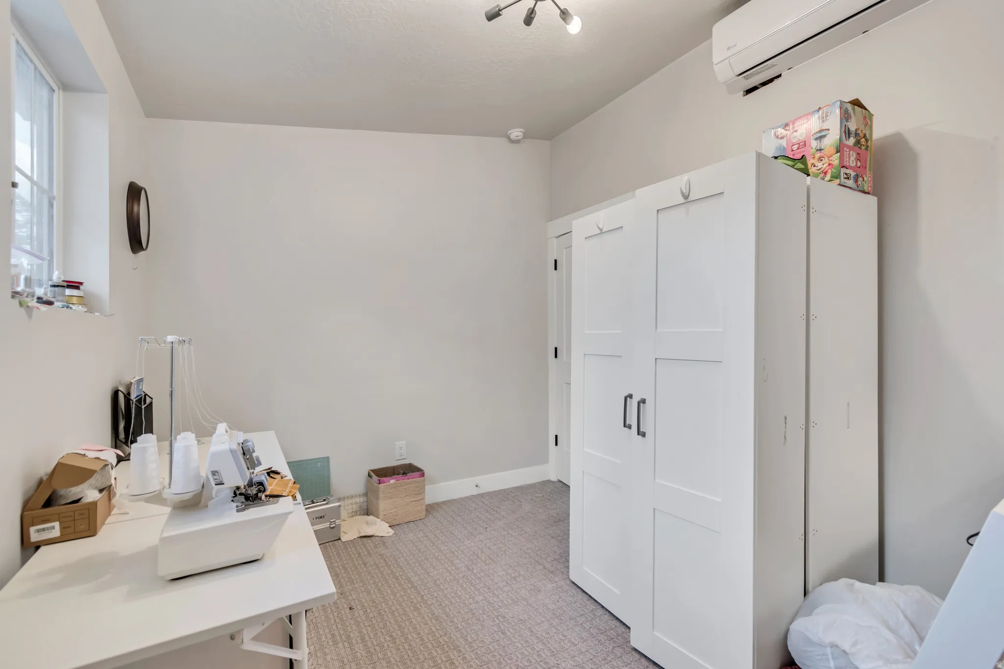 Carpeted room with light neutral walls and a window