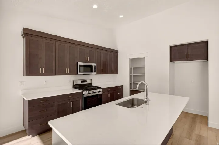 Expansive kitchen island featuring a stainless steel sink and a gooseneck faucet