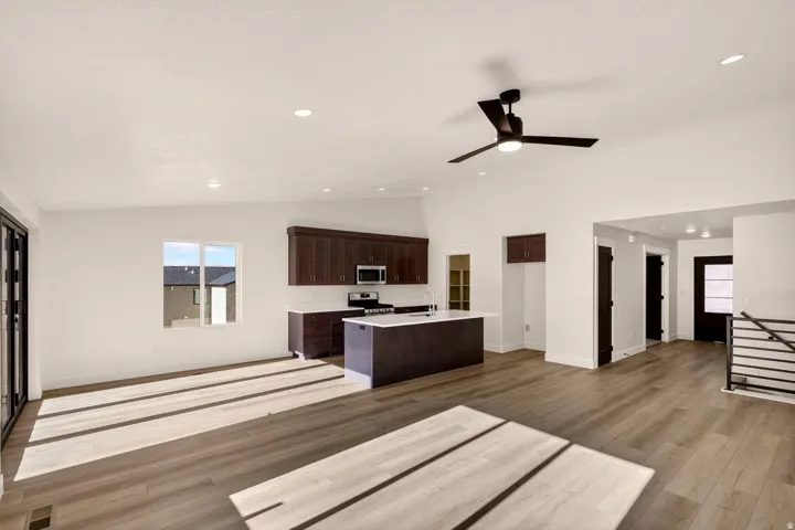 Open-concept living space with wood-finish flooring, recessed lighting, and a modern ceiling fan