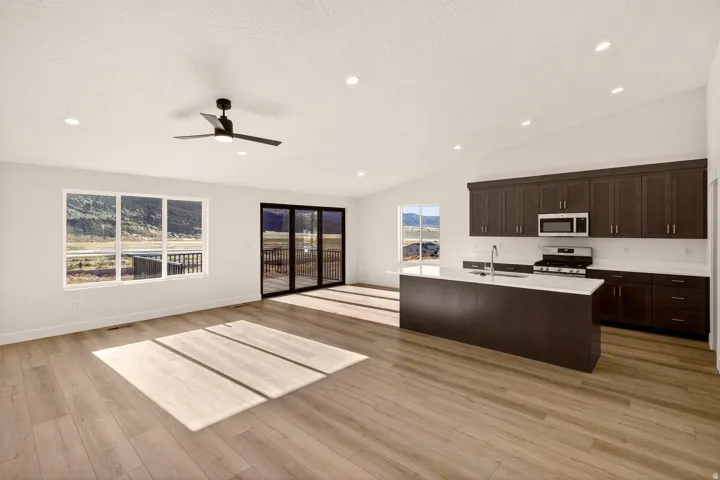 Open-concept living space featuring wood-finish flooring, recessed lighting, and a modern ceiling fan