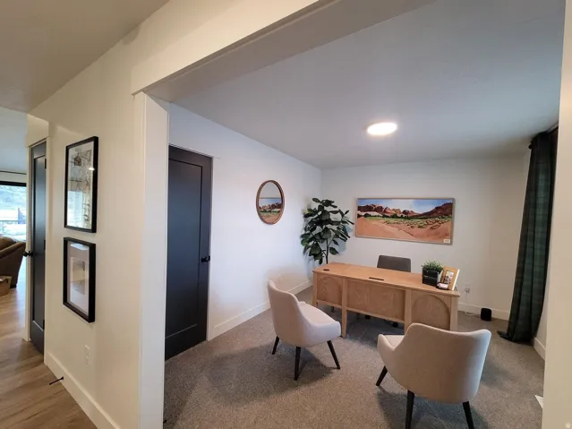 Dedicated office space featuring recessed lighting, a dark privacy door, and neutral-toned carpeting