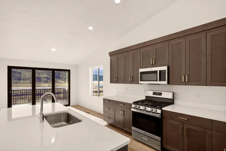 Kitchen featuring a central island with an undermount sink and gooseneck faucet