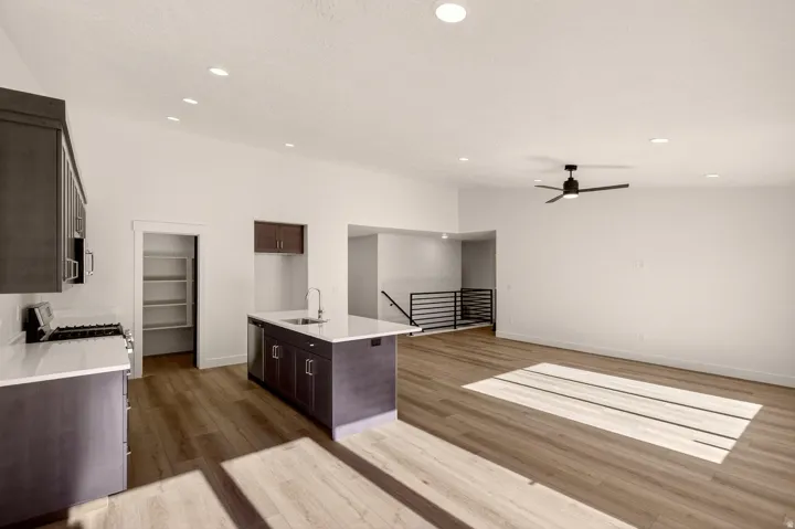 Open-concept living space with wood-finish flooring, recessed lighting, and a modern ceiling fan