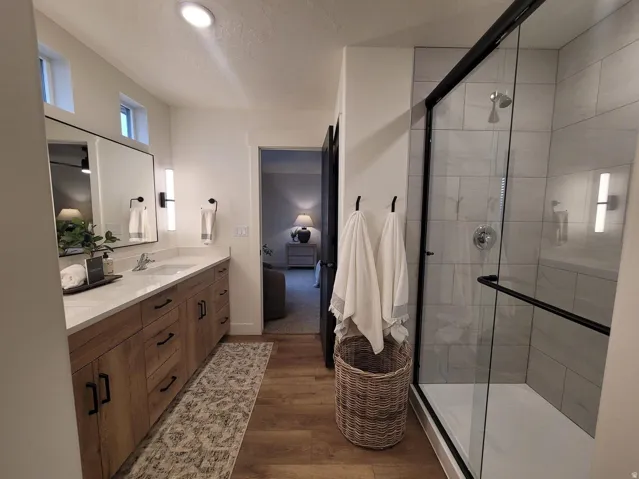 Double vanity with light wood-finish cabinetry and white countertops