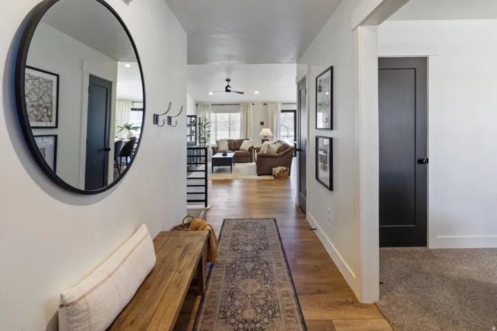 Entryway featuring wood-finish flooring, a large circular mirror, and dark-paneled interior doors