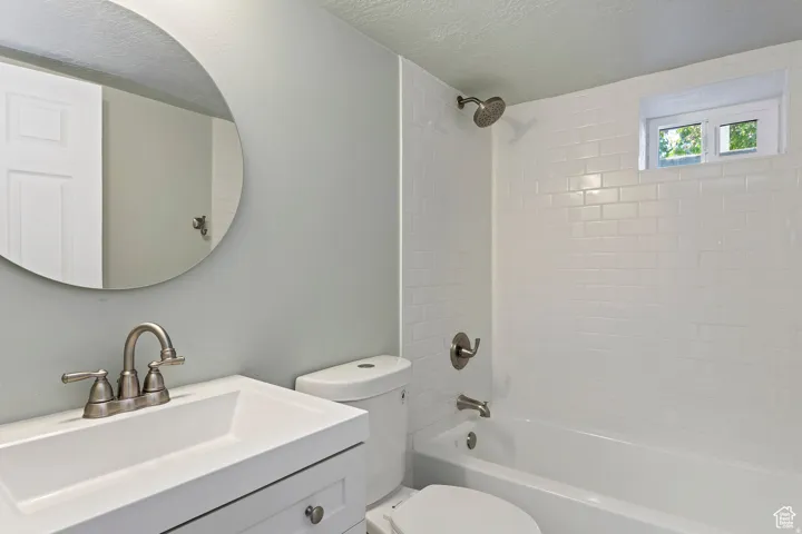 Bathroom featuring white subway tile surround, built-in bathtub, and a window for natural light