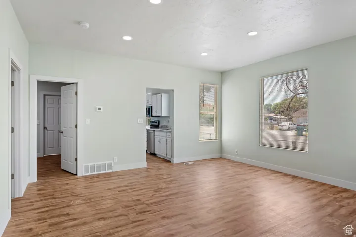 Spacious living area featuring wood-finish flooring, recessed lighting, and light-toned walls