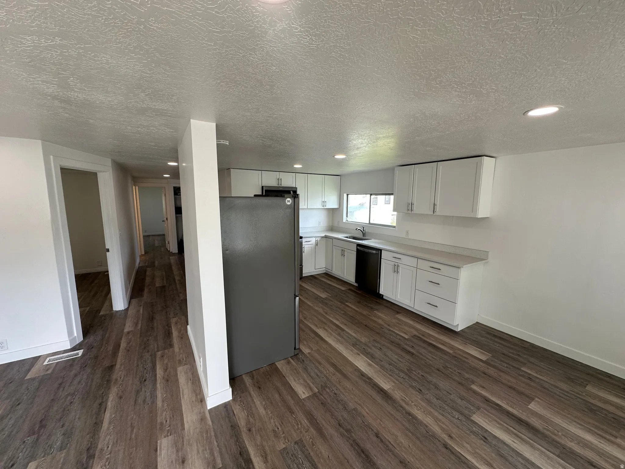 Modern kitchen featuring white cabinetry, light countertops, and integrated appliances