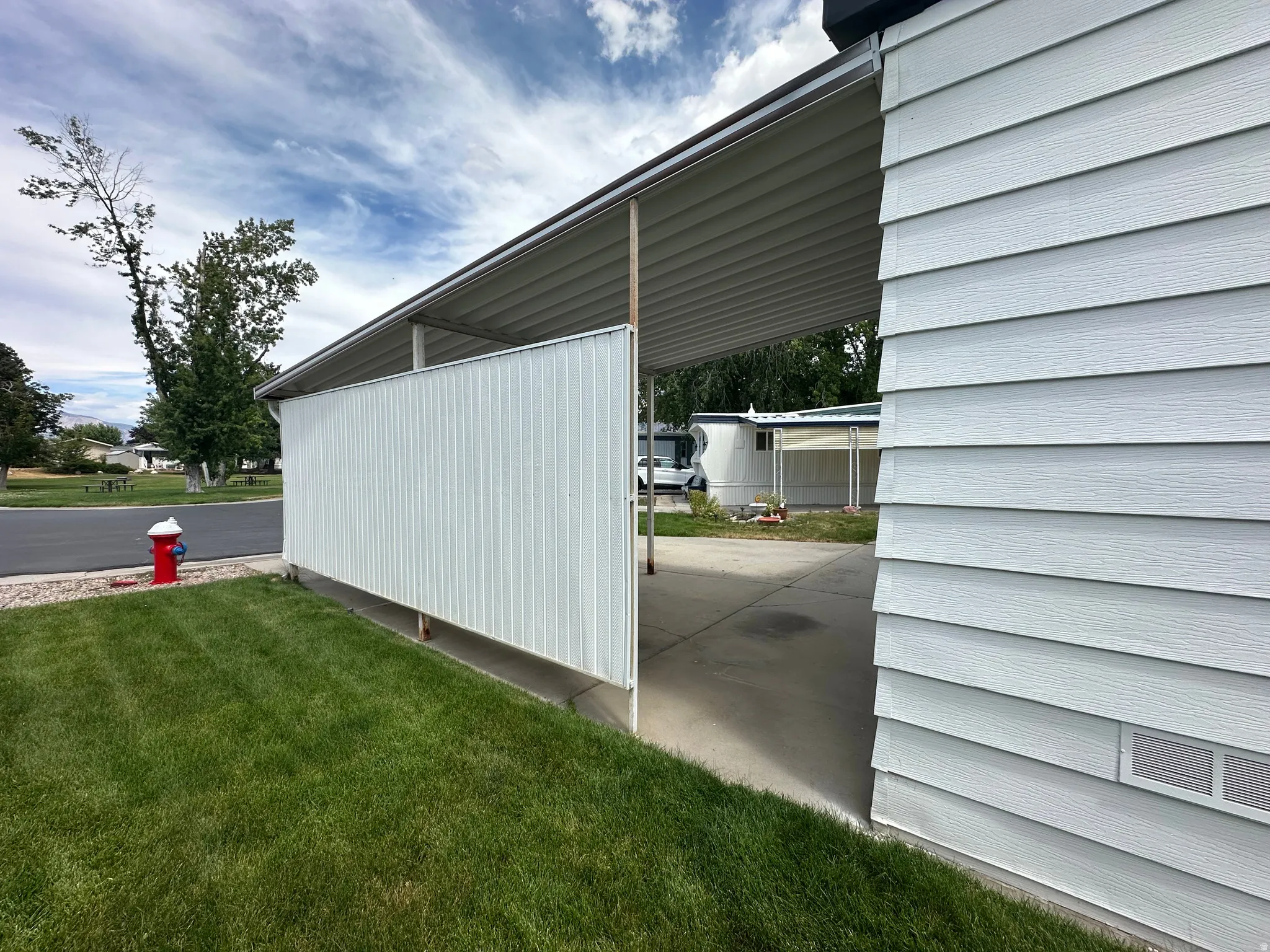 Exterior siding in a horizontal panel finish with a covered carport