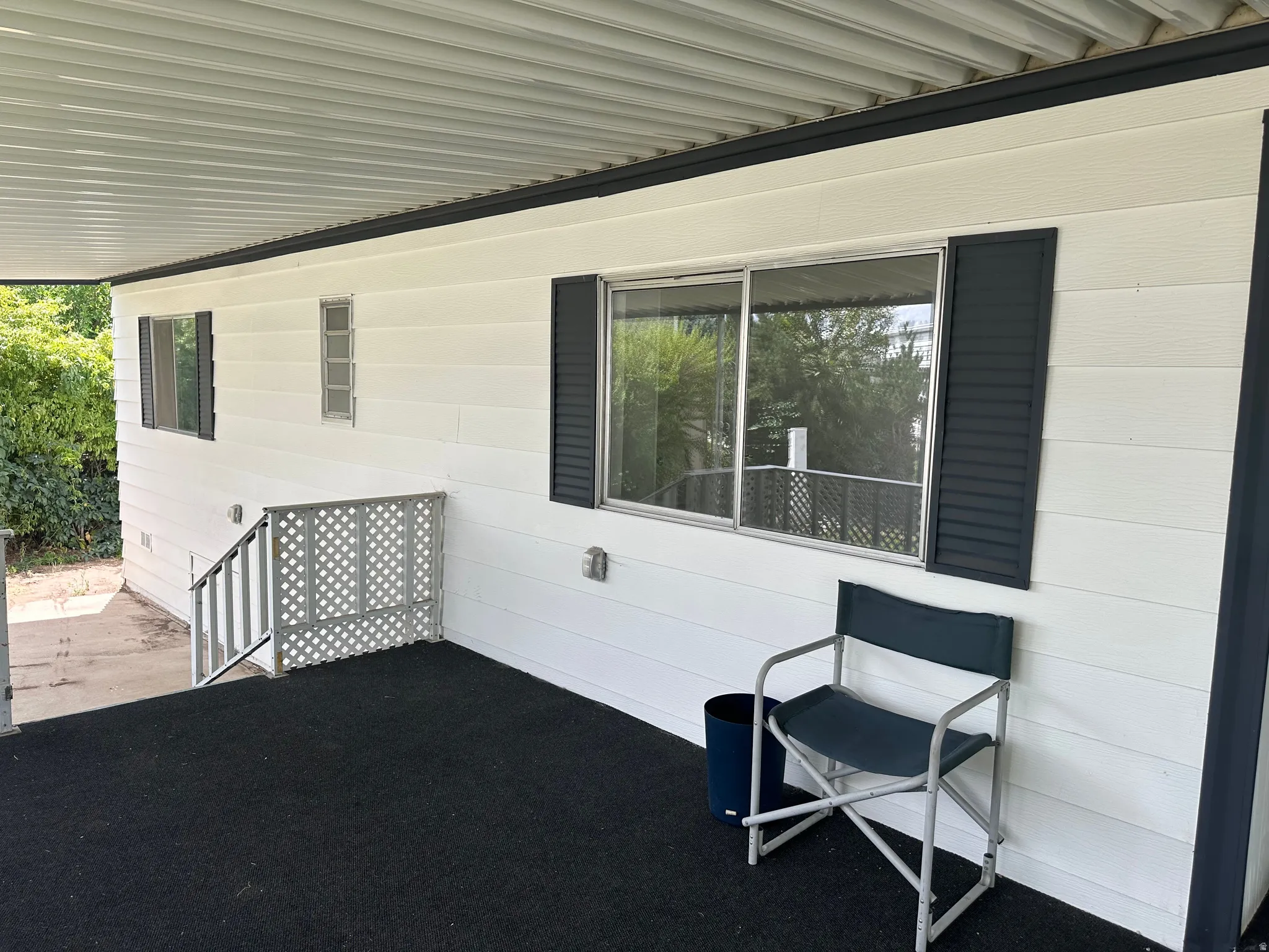 Covered patio featuring a solid roof structure and dark textured flooring
