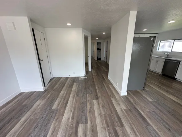 Open concept living area with wood-finish flooring, recessed lighting, and white walls