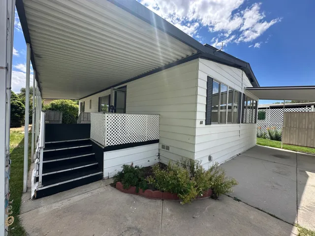 White siding exterior with black shutters and a covered porch