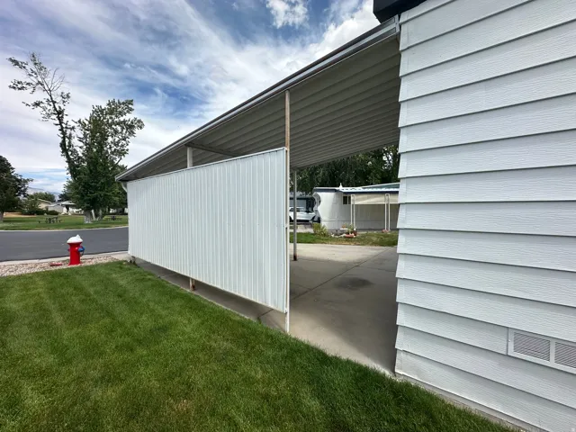 Exterior siding in a horizontal panel finish with a covered carport