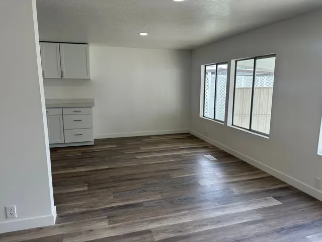 Open-concept space featuring wood-finish flooring, recessed lighting, and white baseboards